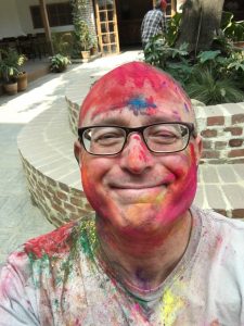 Dr Robin Love smiling while covered in paint.